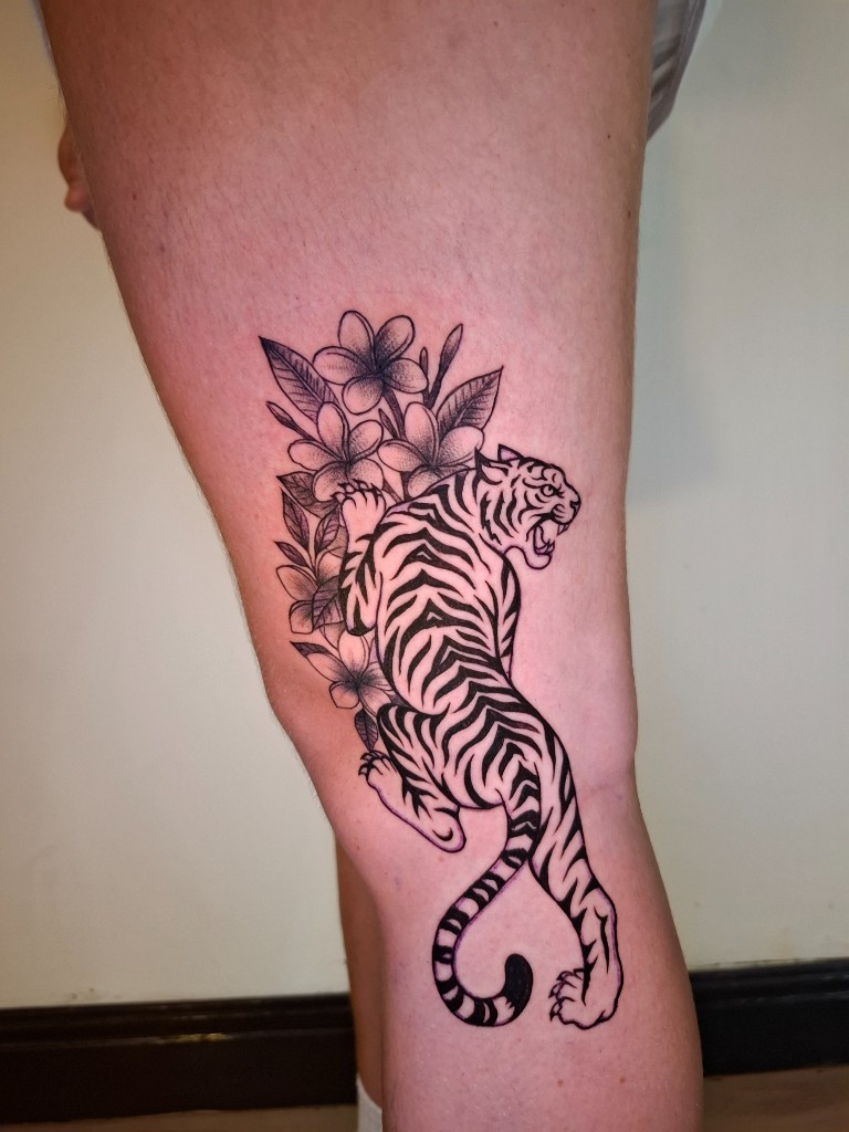 Tiger and plumeria blackwork on thigh